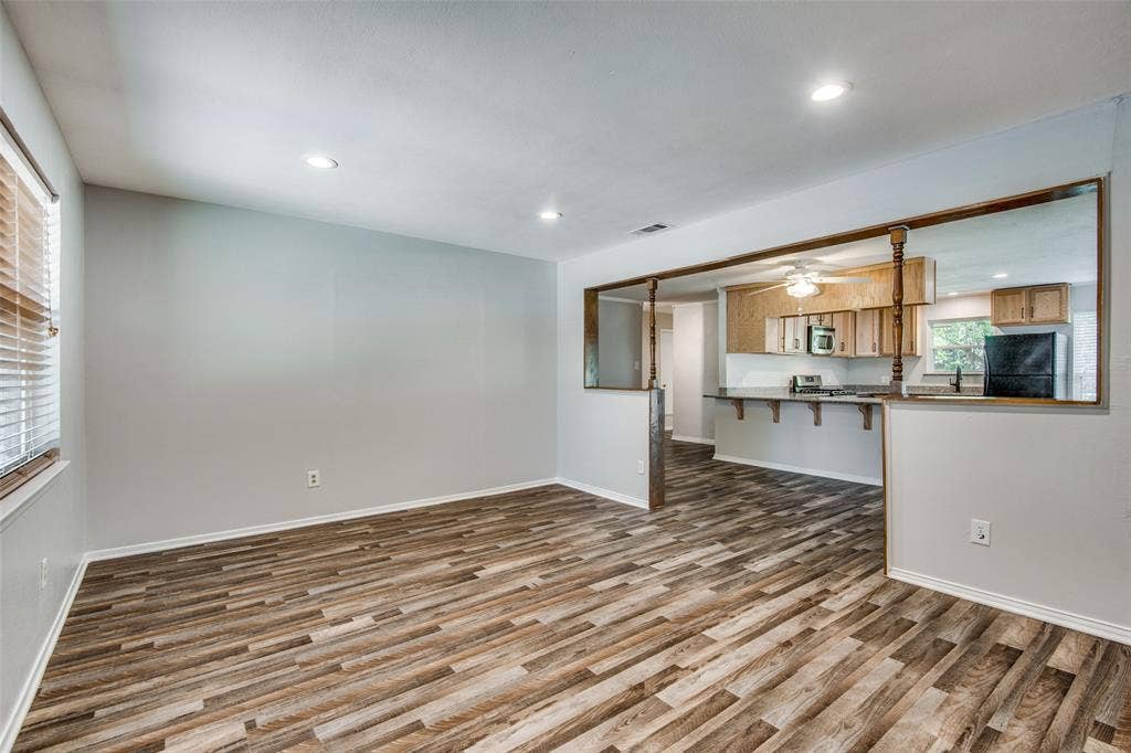 2131 Onetta Drive, Irving, TX 75061 Open-concept area featuring wood-finish flooring, recessed lighting, a breakfast bar with wood-trimmed partition, and kitchen cabinetry