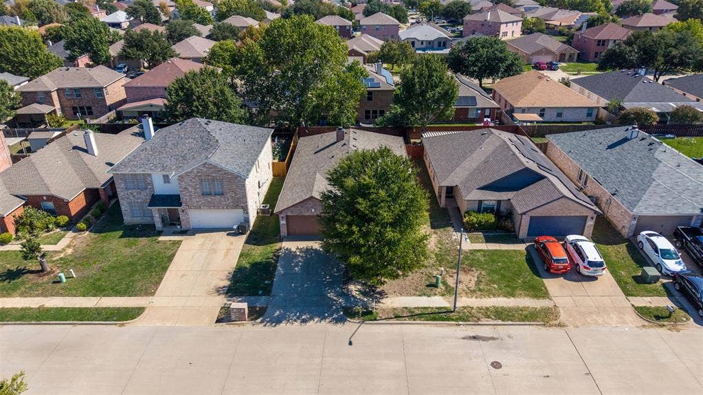 5428 Maverick Drive, Grand Prairie, TX 75052 Single-story brick residence featuring a multi-gable roofline, attached two-car garage, concrete driveway, and mature landscaping