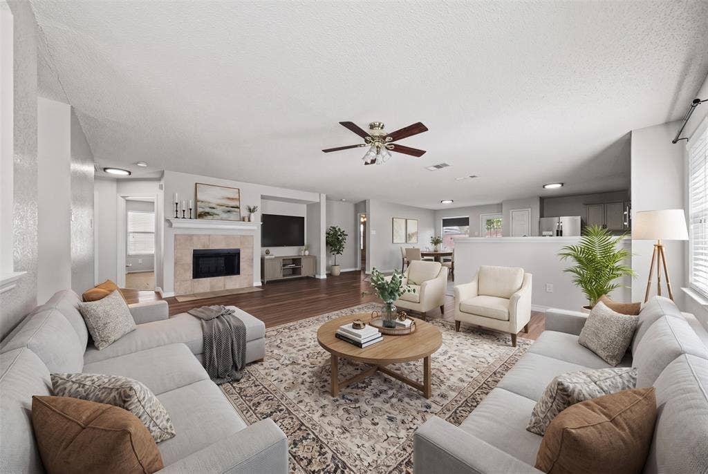 5428 Maverick Drive, Grand Prairie, TX 75052 Living area featuring wood-finish flooring, a fireplace with a neutral tile surround, a central ceiling fan, and recessed lighting