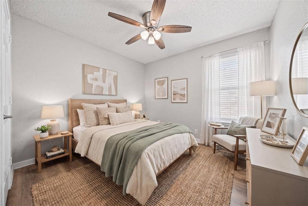 5428 Maverick Drive, Grand Prairie, TX 75052 Room featuring wood-finish flooring, a central multi-blade ceiling fan with integrated lighting, and a large window with vertical blinds