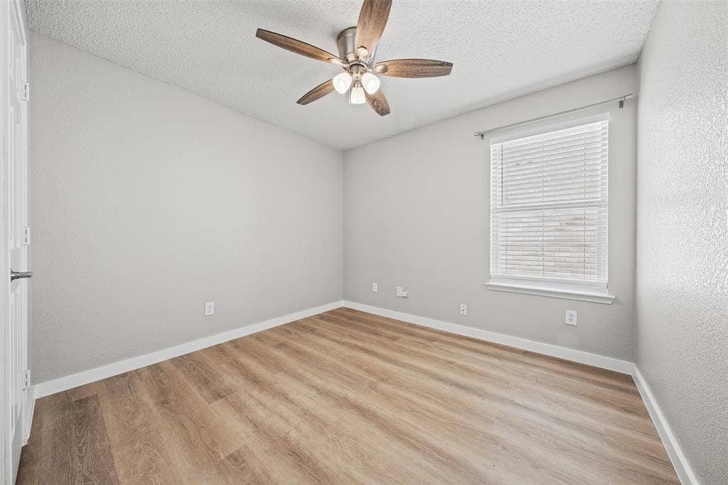 5428 Maverick Drive, Grand Prairie, TX 75052 Wood-finish flooring, neutral wall tones, multi-blade ceiling fan with integrated lighting, and horizontal window blinds