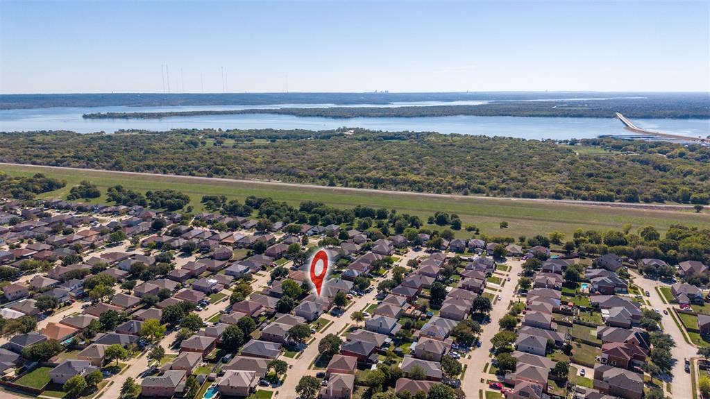 5428 Maverick Drive, Grand Prairie, TX 75052 Aerial perspective showcasing proximity to an expansive reservoir and surrounding undeveloped woodland