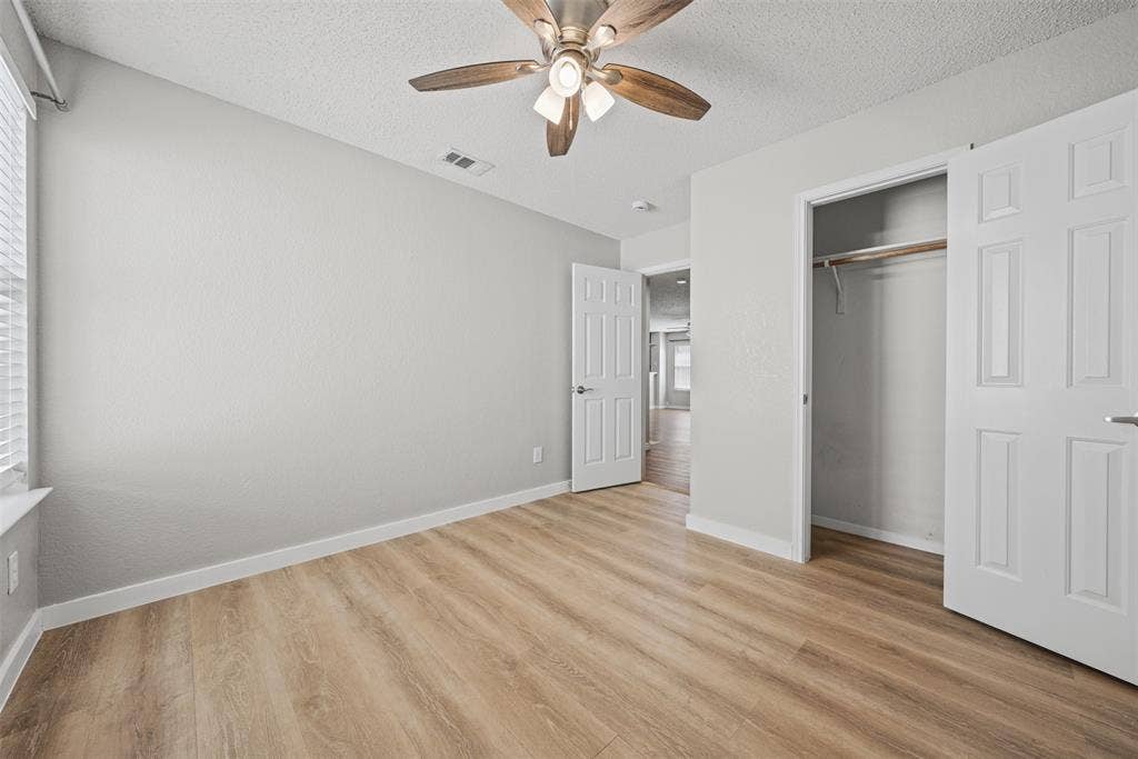 5428 Maverick Drive, Grand Prairie, TX 75052 Room featuring wood-finish flooring, textured ceilings, a ceiling fan with integrated lighting, and a closet with a built-in hanging rod