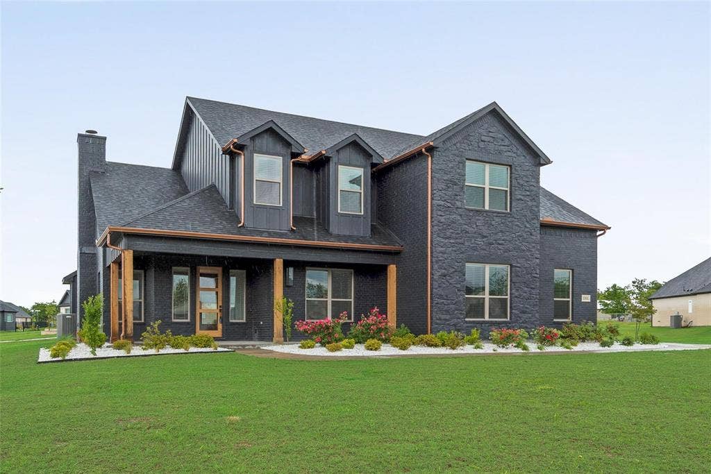 1001 Devoss Court, Caddo Mills, TX 75135 Two-story exterior featuring a dark brick facade, vertical siding, copper gutters, natural wood posts, and a shingled roof