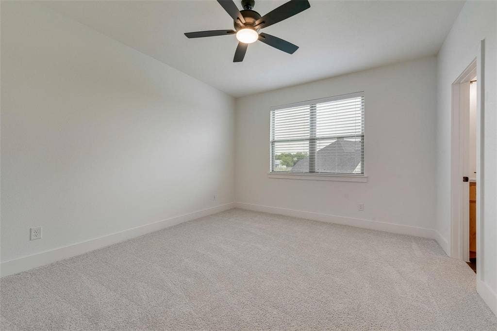 1001 Devoss Court, Caddo Mills, TX 75135 Neutral-toned carpeted flooring, window with horizontal blinds, and a central ceiling fan with integrated lighting
