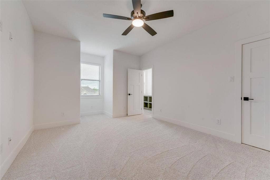 1001 Devoss Court, Caddo Mills, TX 75135 Neutral-toned wall-to-wall carpeting, ceiling fan with integrated lighting, window with horizontal blinds, and two-panel interior doors with matte black hardware