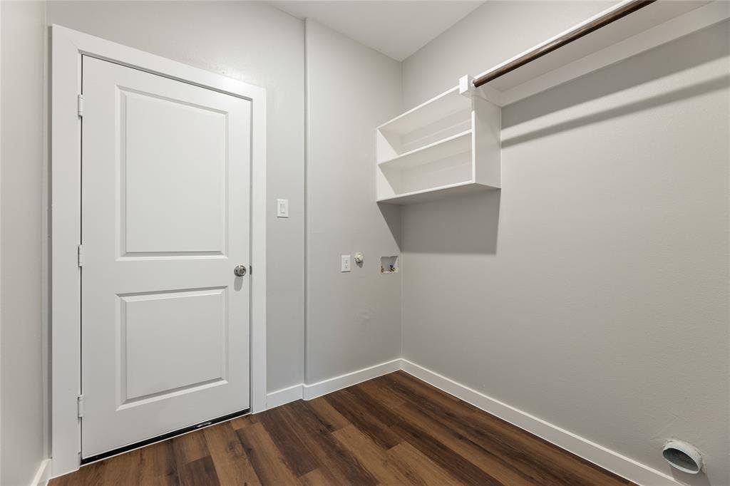 1242 Seminole Drive, Dallas, TX 75217 Utility area featuring wood-finish flooring, a solid-core interior door, wall-mounted white shelving, and a built-in hanging rod