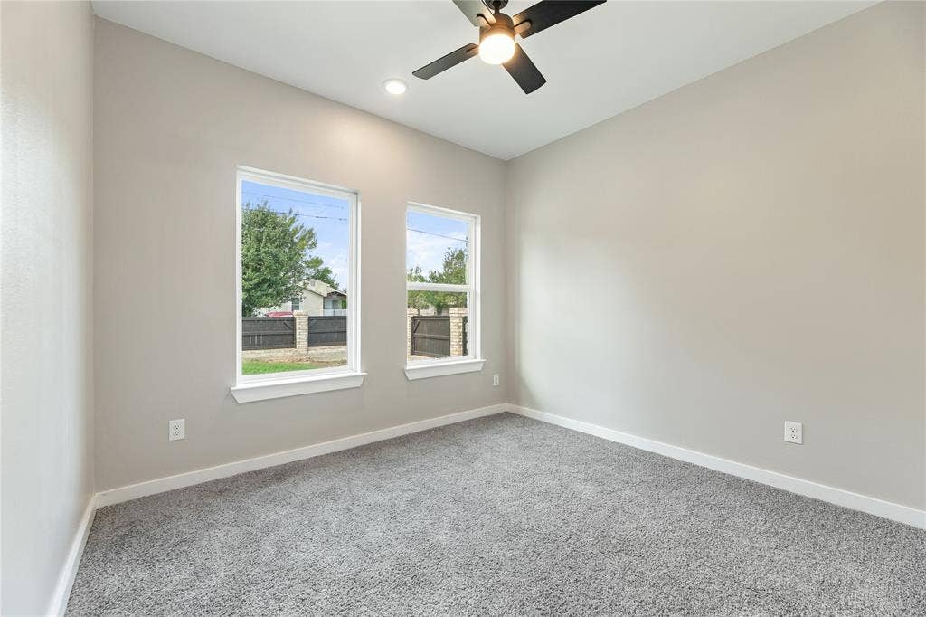 1242 Seminole Drive, Dallas, TX 75217 Neutral interior walls, plush carpeting, dual windows, recessed lighting, and a modern ceiling fan with integrated light fixture