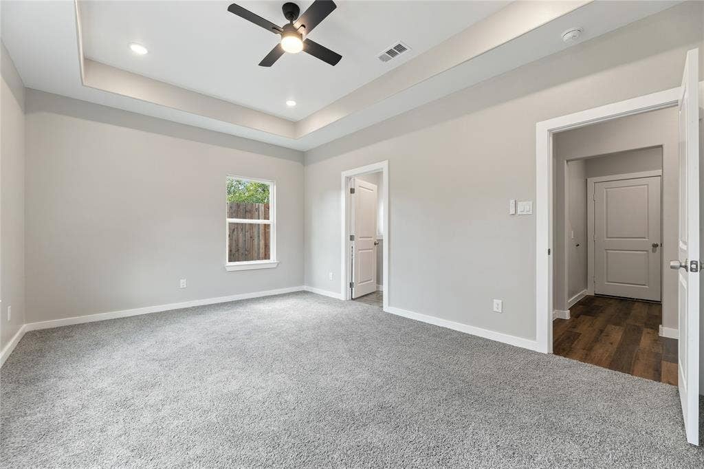 1242 Seminole Drive, Dallas, TX 75217 Tray ceiling with recessed lighting, integrated ceiling fan, neutral wall-to-wall carpeting, and interior panel doors