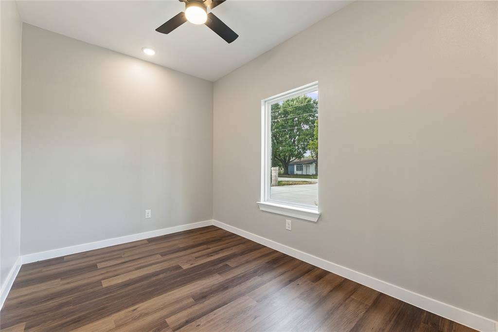 1242 Seminole Drive, Dallas, TX 75217 Neutral-toned interior featuring wood-finish flooring, a single-hung window with a sill, a ceiling-mounted light fixture with fan blades, and a recessed ceiling light