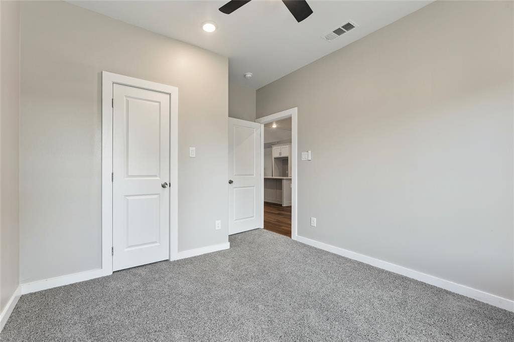 1242 Seminole Drive, Dallas, TX 75217 Neutral wall tones with grey carpeting, recessed lighting, and a multi-speed ceiling fan