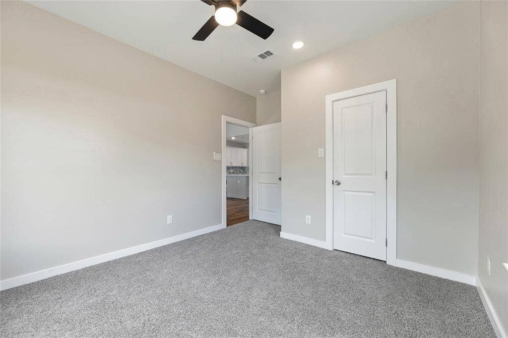 1242 Seminole Drive, Dallas, TX 75217 Neutral wall palette featuring plush carpeting, a multi-blade ceiling fan, and classic paneled interior doors