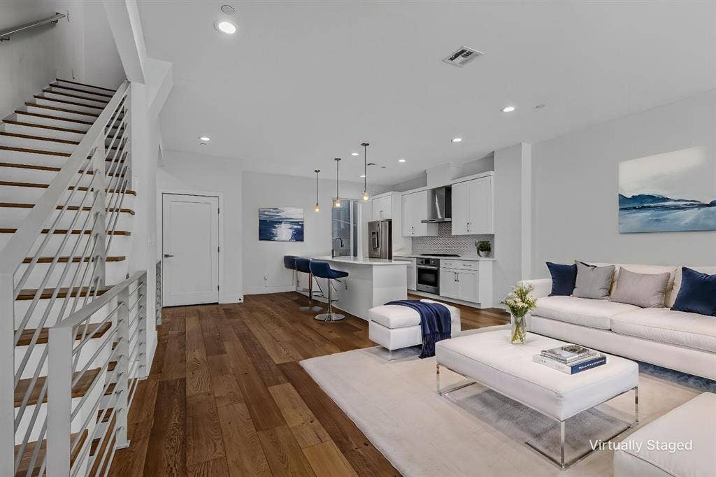 2222 Moser Avenue, #105, Dallas, TX 75206 Open-concept interior featuring wood-finish flooring, a kitchen island with pendant lighting, shaker-style cabinetry, and a stainless steel range hood