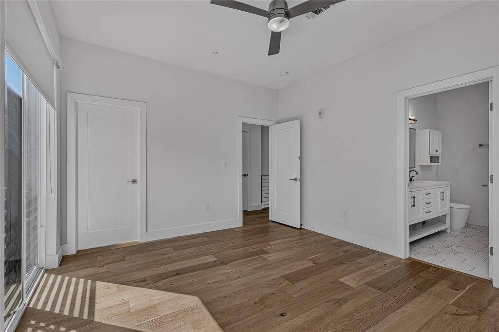 2222 Moser Avenue, #105, Dallas, TX 75206 Interior space featuring wood-finish flooring, a ceiling fan, sliding glass doors, and a bathroom equipped with a white vanity and hexagonal floor tile
