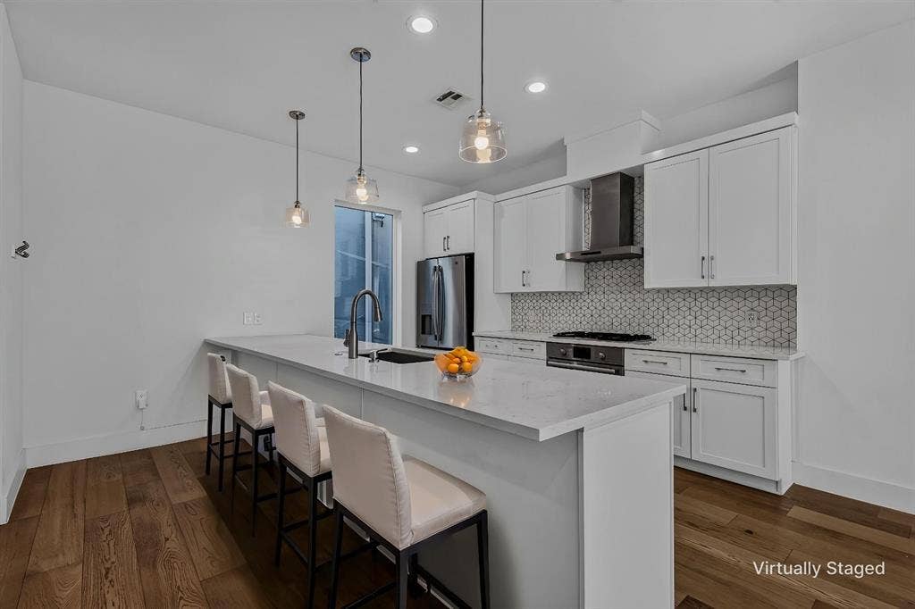 2222 Moser Avenue, #105, Dallas, TX 75206 Kitchen featuring white shaker-style cabinetry, quartz countertops, patterned tile backsplash, stainless steel appliances, and wood-finish flooring