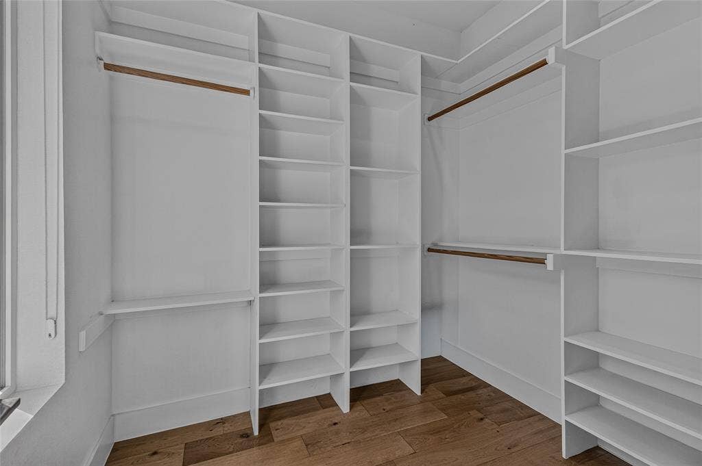 2222 Moser Avenue, #105, Dallas, TX 75206 Primary Walk-in closet featuring white built-in shelving, wooden closet rods, and wood-finish flooring