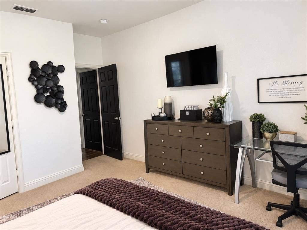 Interior space featuring high ceilings, wall-to-wall carpeting, and contrasting black six-panel interior doors
