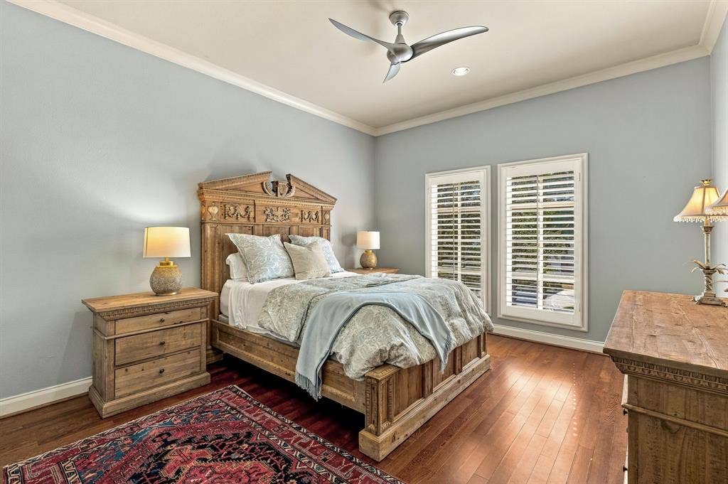 Wood-finish flooring, dual windows with plantation shutters, recessed lighting, and a modern ceiling fan