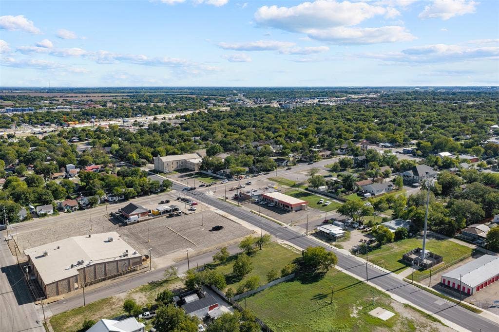 920-928 S 18th Street, Waco, TX 76706 Aerial view of an urban landscape featuring paved roadways, commercial structures, expansive parking lots, and established tree canopy