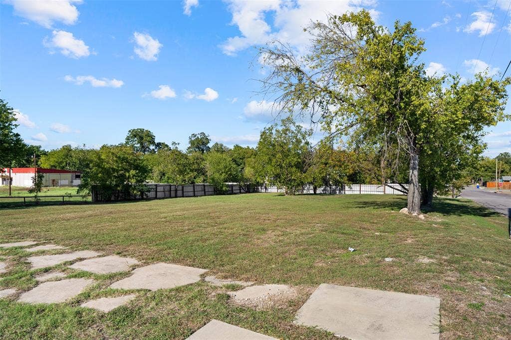 920-928 S 18th Street, Waco, TX 76706 Expansive open lot featuring a level grass expanse, mature trees, and perimeter wood-slat fencing