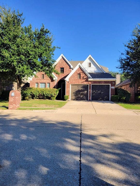 4308 Lee Hutson Drive, Sachse, TX 75048 Brick facade exterior featuring a multi-gabled roofline, concrete driveway, and attached two-car garage