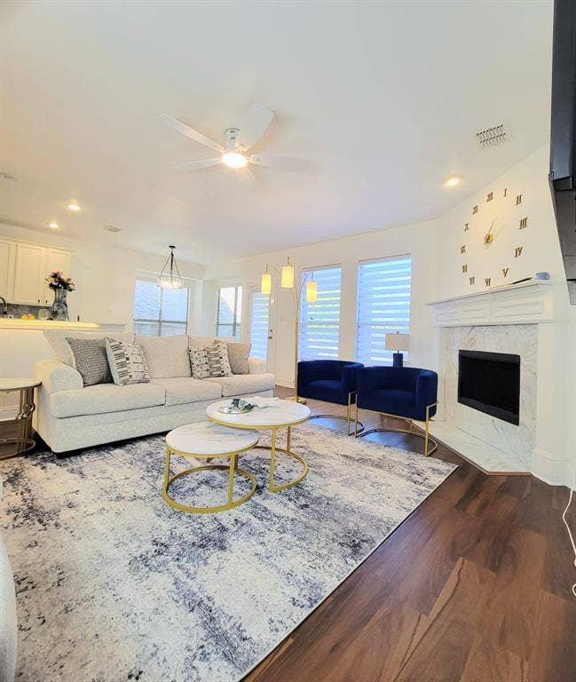 4308 Lee Hutson Drive, Sachse, TX 75048 Living area featuring a fireplace with a white mantel and stone-finish surround, wood-finish flooring, recessed lighting, and a ceiling fan