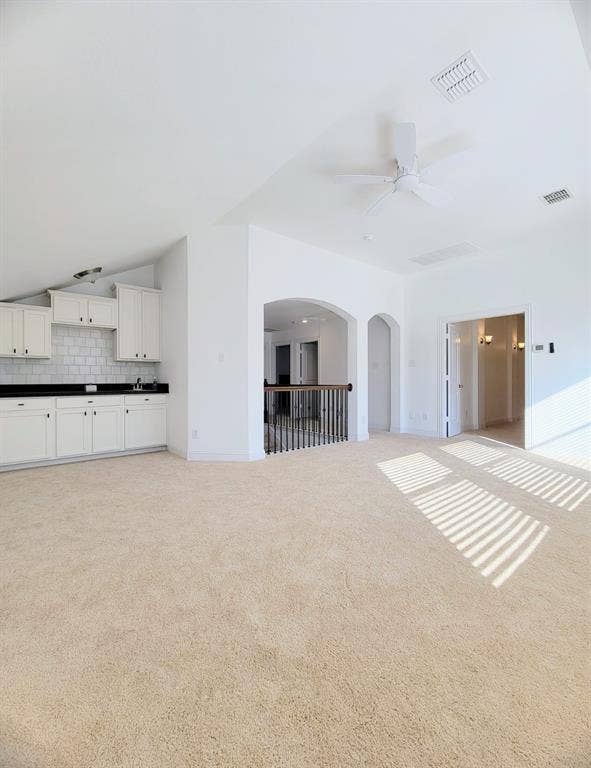 4308 Lee Hutson Drive, Sachse, TX 75048 Vaulted ceilings, built-in cabinetry with stone-finish countertops, subway tile backsplash, and decorative archways with a metal balustrade