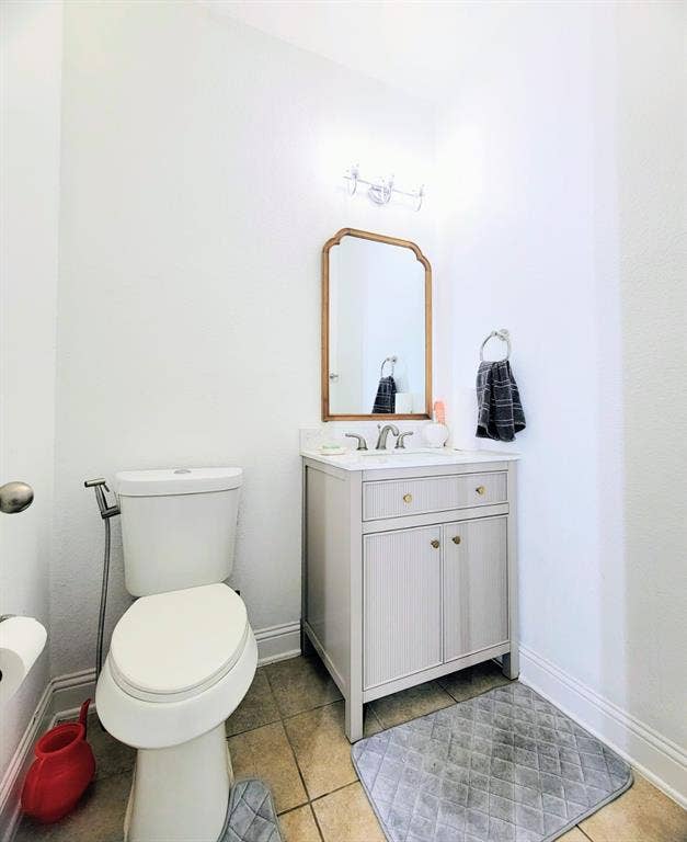 4308 Lee Hutson Drive, Sachse, TX 75048 Light-toned vanity cabinet with stone-finish countertop, undermount sink, metallic hardware, and arched wall-mounted mirror