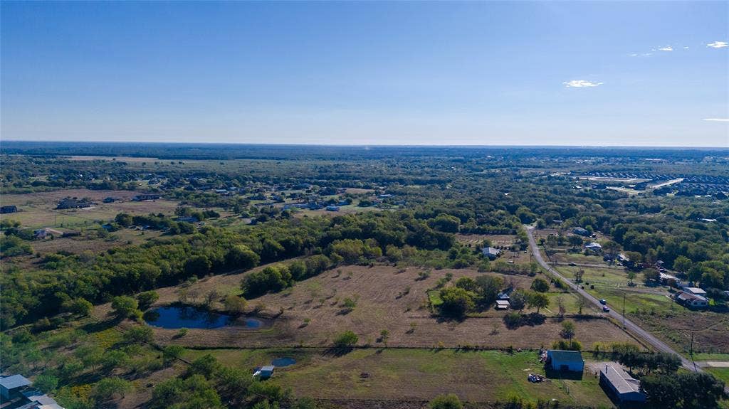 212 Old Wagon Road, Royse City, TX 75189 Aerial perspective of expansive acreage featuring a pond, mature trees, and cleared pasture land
