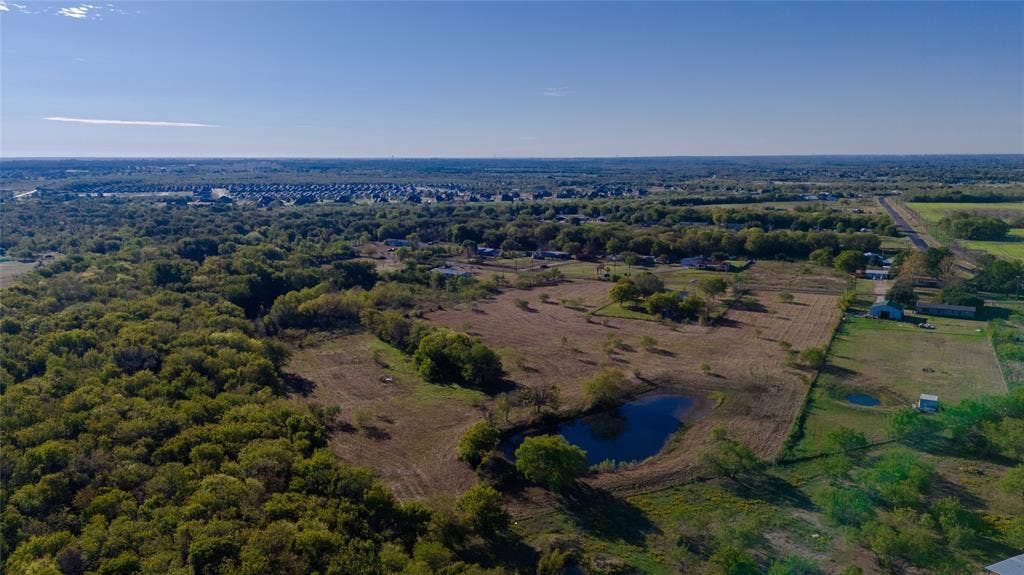 212 Old Wagon Road, Royse City, TX 75189 Expansive acreage featuring mature tree lines, open pastoral space, and a private pond
