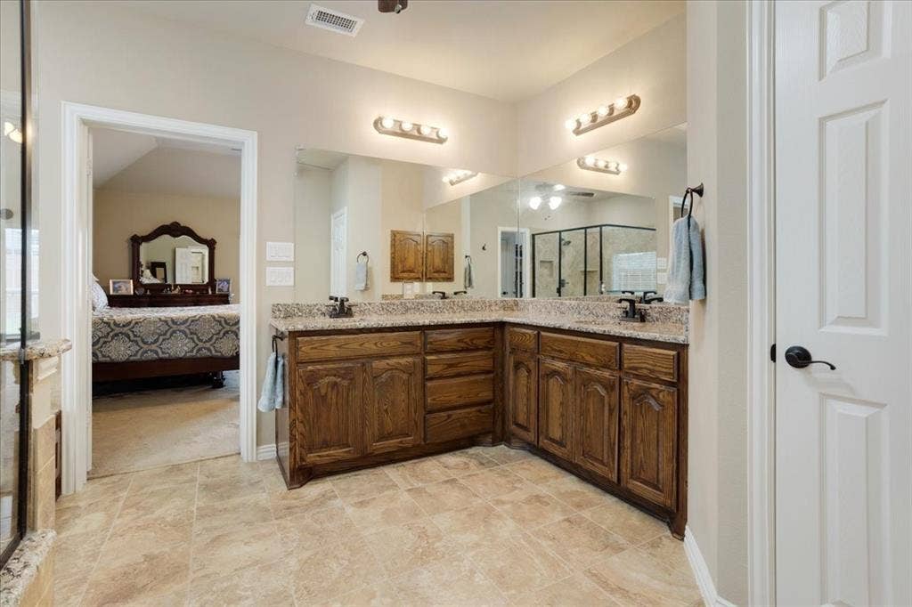 319 Westphalian Drive, Celina, TX 75009 Bathroom vanity featuring dual sinks with granite countertops and wood cabinetry