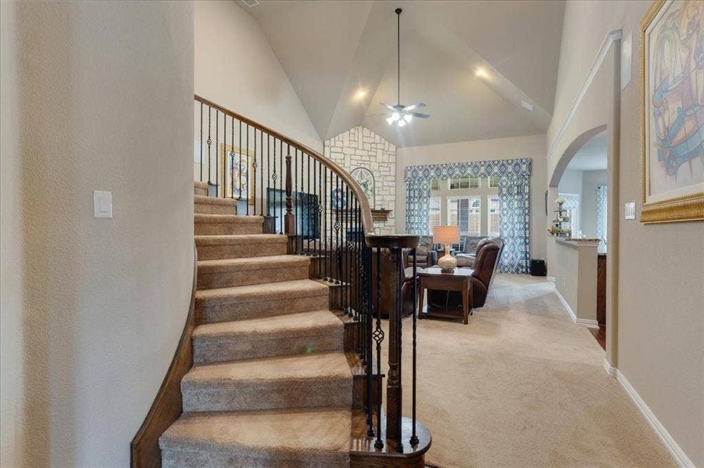 319 Westphalian Drive, Celina, TX 75009 Curved staircase with dark wood handrail and wrought iron spindles