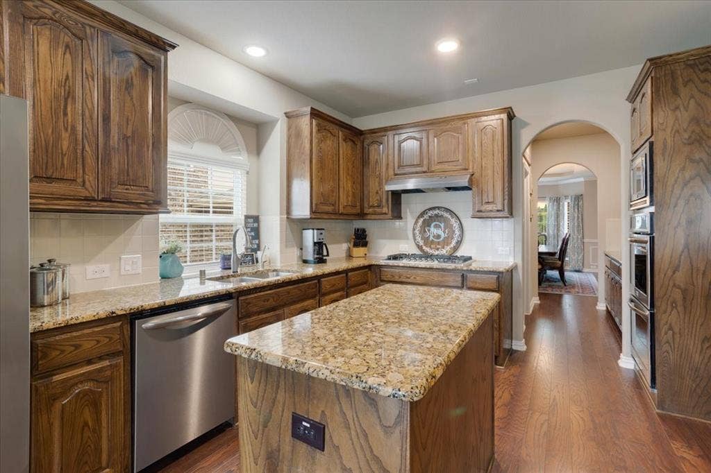 319 Westphalian Drive, Celina, TX 75009 Kitchen featuring a central island with a granite countertop, wood-finish flooring, recessed lighting, and stainless steel appliances