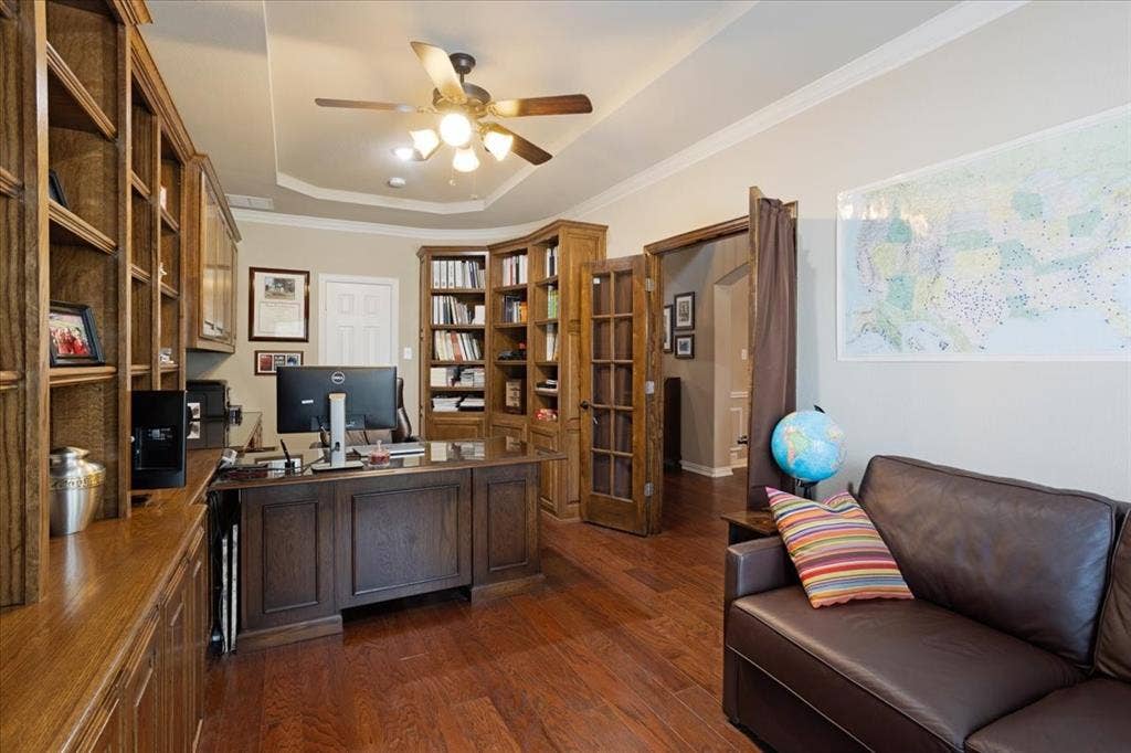 319 Westphalian Drive, Celina, TX 75009 Home office featuring extensive built-in wood cabinetry, wood-finish flooring, a tray ceiling with a ceiling fan, and French doors