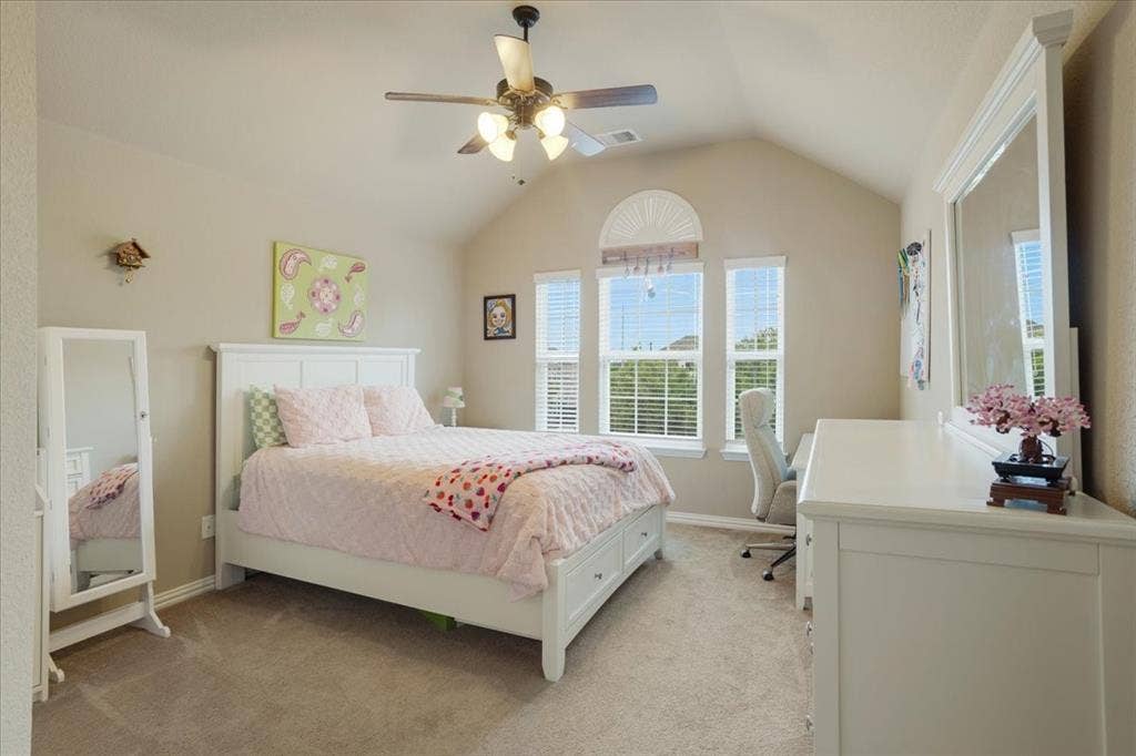 319 Westphalian Drive, Celina, TX 75009 Bedroom featuring a vaulted ceiling with a ceiling fan, three windows with blinds, and neutral carpet flooring