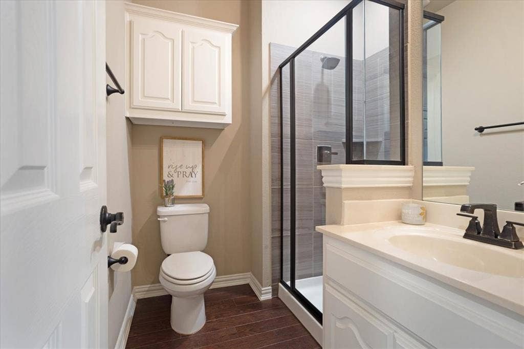 319 Westphalian Drive, Celina, TX 75009 Bathroom featuring a walk-in shower with dark-framed glass enclosure, grey tile surround, and built-in niche