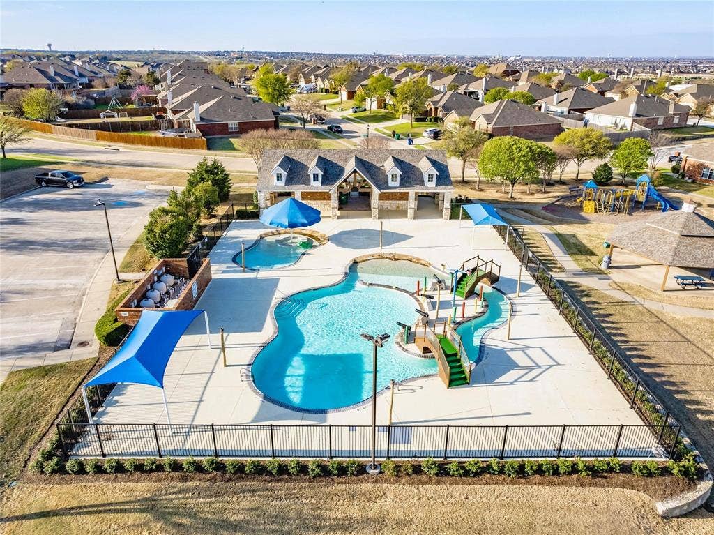 319 Westphalian Drive, Celina, TX 75009 Community pool complex featuring a large swimming pool with water features, a separate wading pool, and a bathhouse with stone and siding accents