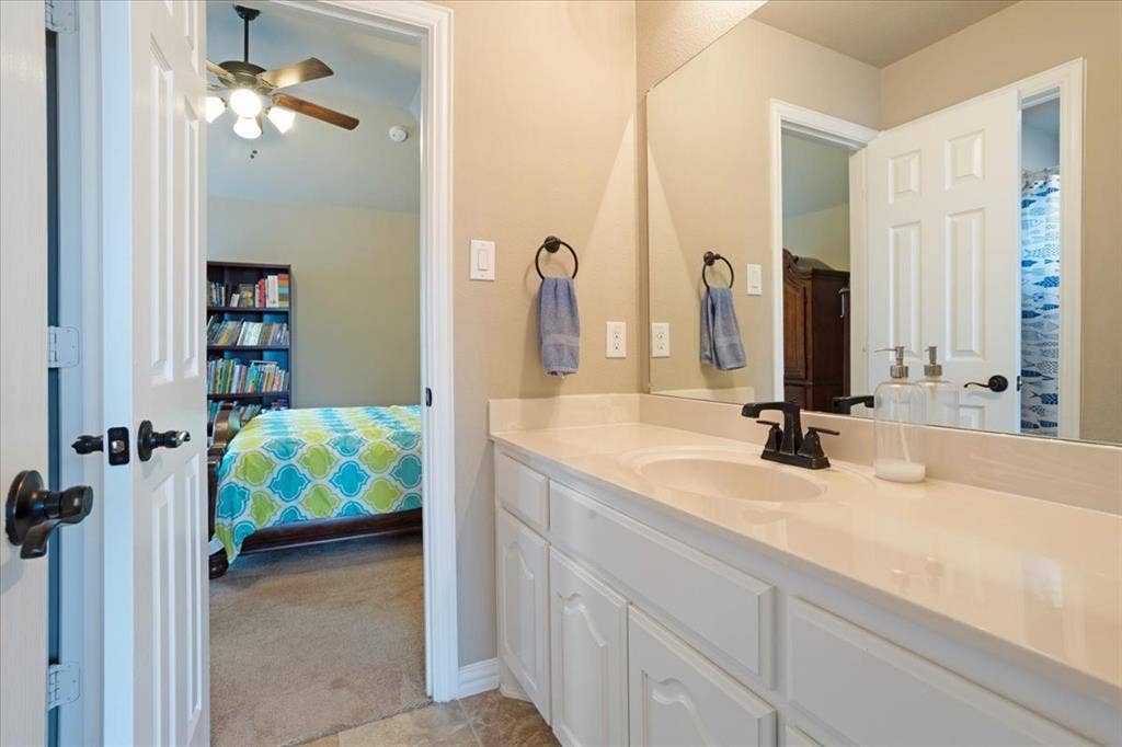 319 Westphalian Drive, Celina, TX 75009 Bathroom vanity featuring a single undermount sink, a dark bronze faucet, and white cabinetry