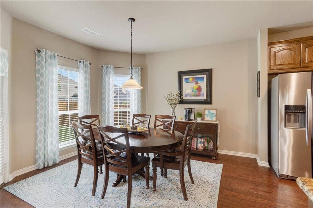 319 Westphalian Drive, Celina, TX 75009 Dining area featuring a bay window, wood-finish flooring, and a contemporary pendant light fixture
