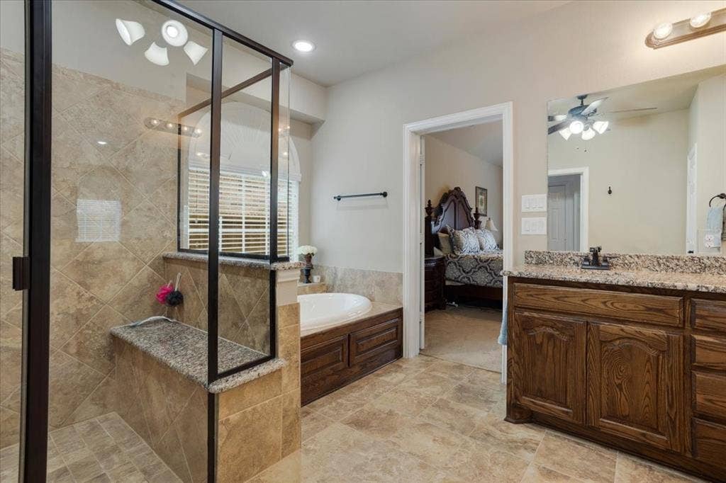 319 Westphalian Drive, Celina, TX 75009 Spacious bathroom featuring a glass-enclosed shower with a built-in bench, a jetted soaking tub, a double vanity with granite countertop, and tiled flooring