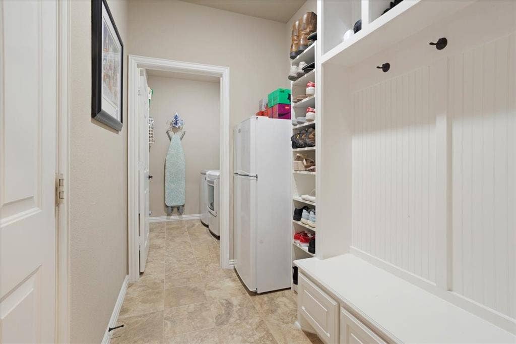 319 Westphalian Drive, Celina, TX 75009 Entryway mudroom featuring built-in storage with open shelving, integrated bench seating with cabinet storage, and beadboard paneling