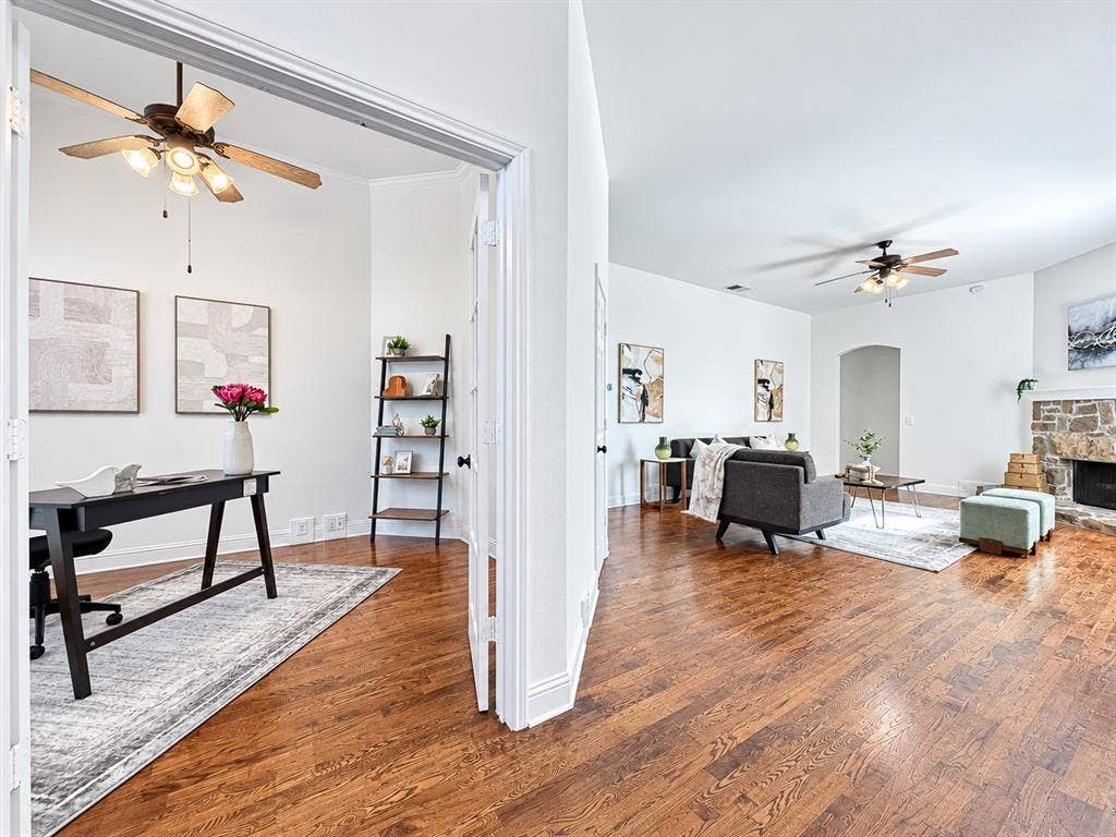 7514 Naples Lane, Frisco, TX 75035 Wood-finish flooring, stone-surround fireplace, multi-light ceiling fans, and French doors
