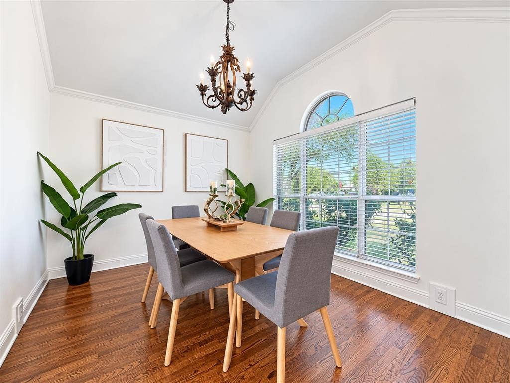 7514 Naples Lane, Frisco, TX 75035 Vaulted ceilings, wood-finish flooring, ornate iron chandelier, and large window with an arched transom
