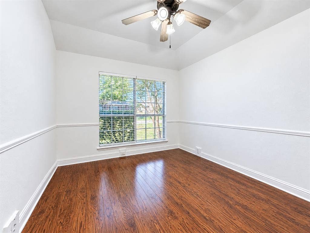 7514 Naples Lane, Frisco, TX 75035 Room featuring wood-finish flooring, tray ceiling, chair rail molding, and a ceiling fan with integrated lighting