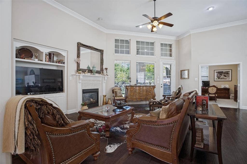 701 Crabapple Way, McKinney, TX 75072 Vaulted ceilings, dark wood-finish flooring, built-in cabinetry, fireplace with a mantle, and grid-pattern windows