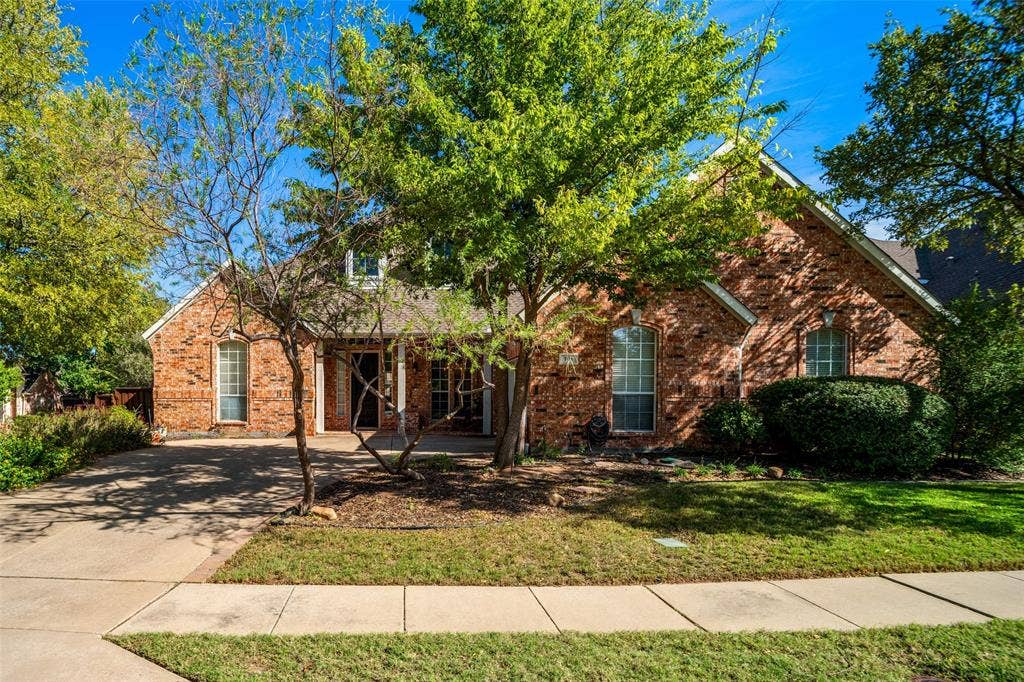701 Crabapple Way, McKinney, TX 75072 Traditional brick exterior featuring a multi-gabled roofline, arched entryway, and multi-pane windows