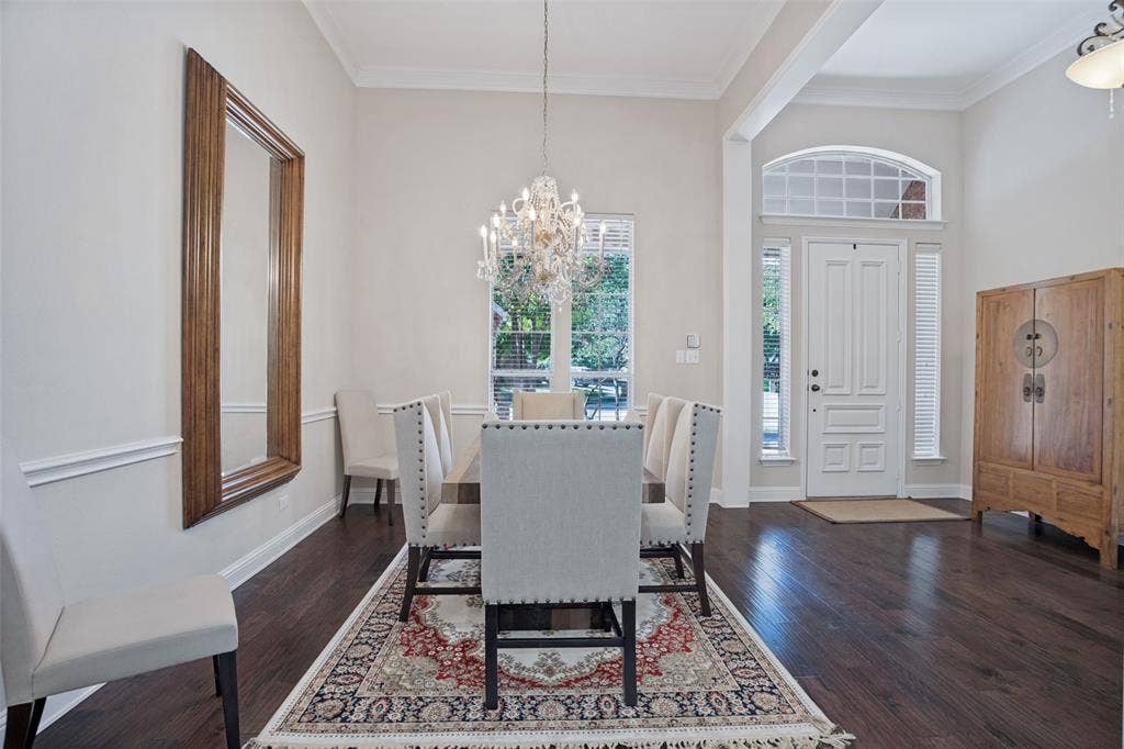 701 Crabapple Way, McKinney, TX 75072 Formal dining area featuring dark wood-finish flooring, a decorative chandelier, wainscoting, and a panelled front door with an arched transom window
