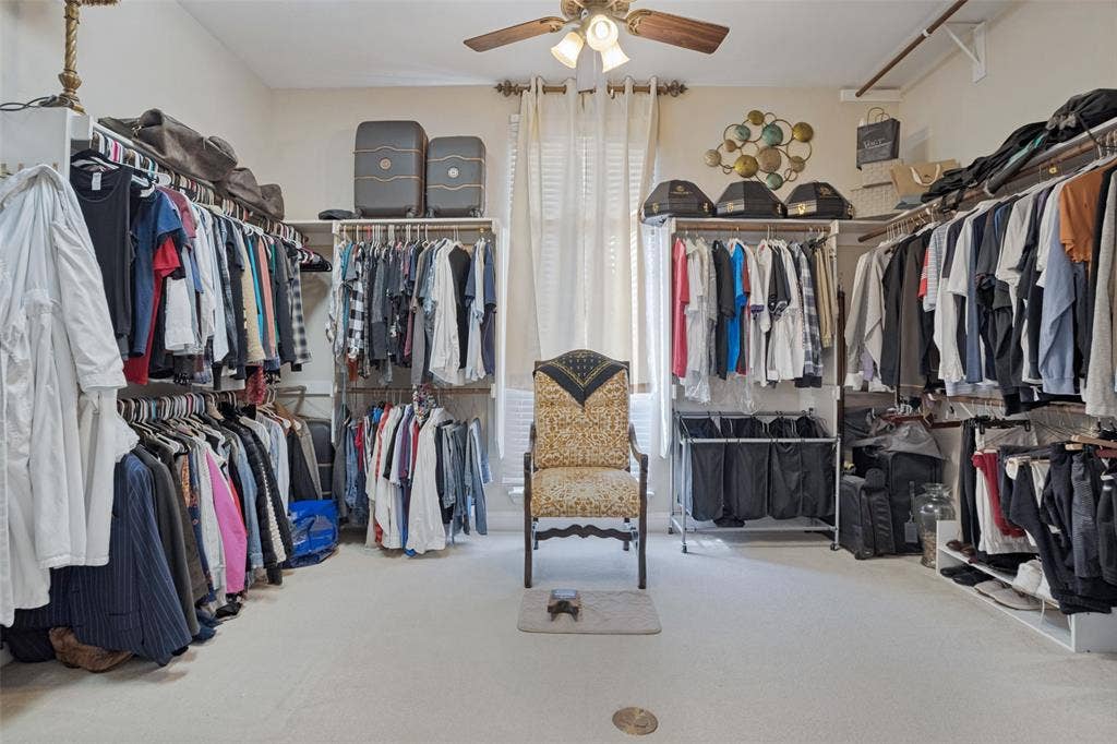 701 Crabapple Way, McKinney, TX 75072 Customized dressing area featuring extensive wall-mounted shelving, integrated hanging rods, a ceiling fan with light fixture, and a central window with drapery hardware