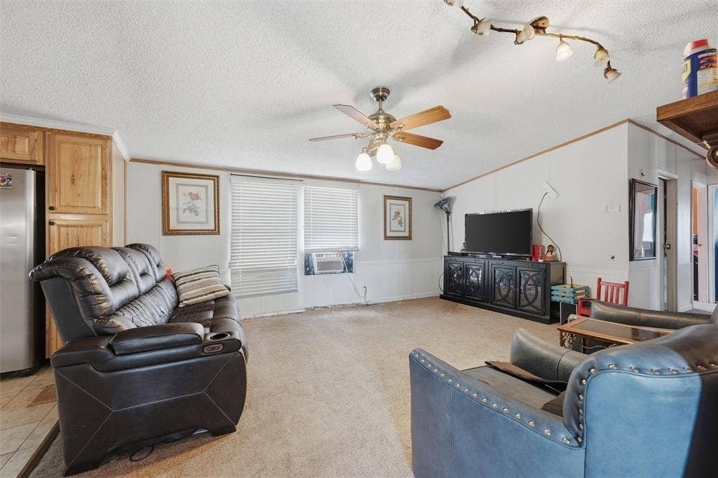 866 Old Church Rd, Waxahachie, TX 75165 Living area featuring vaulted ceilings, a central ceiling fan with integrated lighting, track lighting, and horizontal window blinds