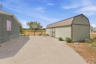 866 Old Church Rd, Waxahachie, TX 75165 Concrete patio area featuring a detached storage building with a metal roof and exterior siding